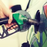 man pumping gasoline fuel in car at gas station