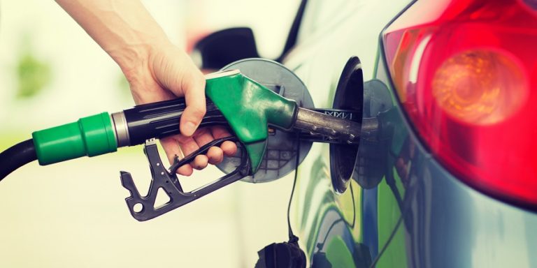 man pumping gasoline fuel in car at gas station